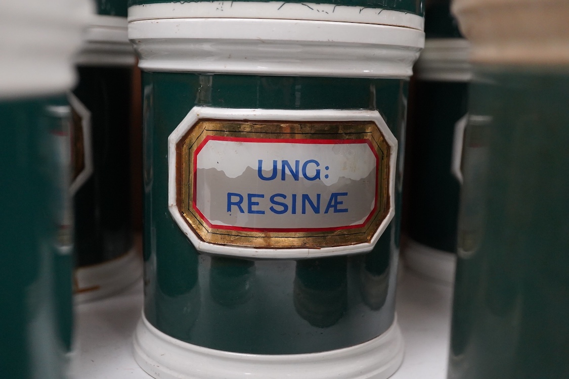 A collection of sixteen 19th/early 20th century ceramic lidded green apothecary jars, with labels painted within panels with raised ceramic edges and gilt lined, examples including; Ung: Zinci, Ung: Sulphur:, Mel: Boraci